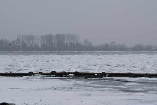 Frozen river with accumulated drift ice putting preasure on dock