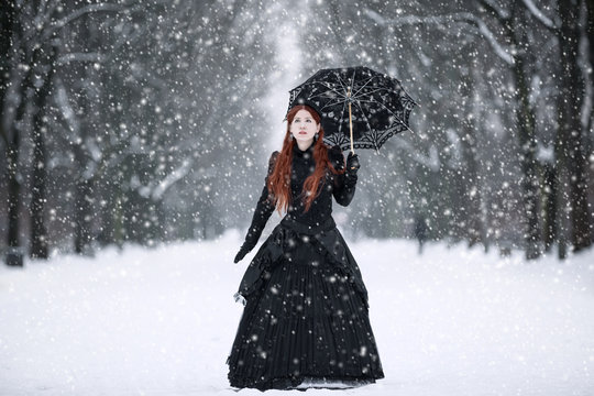 Woman in black Victorian dress in the winter park