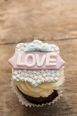 The cupcake with the word love on a brown background. Valentine's day