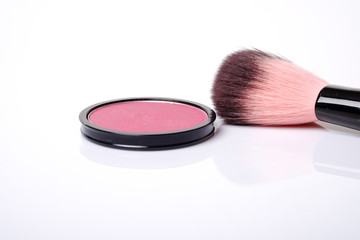 Cosmetic pink blush on and makeup brush.