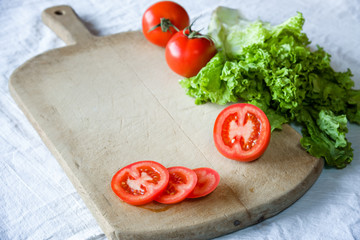 Tomatoes and lettuce on a wooden background.