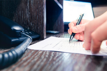 Business man writes contract at work