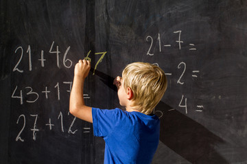 niño aprendiendo matematicas en un pizarron