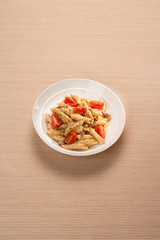 Cheese and mushroom pasta with tomatoes. On striped wooden background.