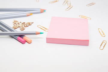 Notebook with stationery and pencils on a white table