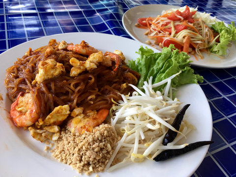 Background Thai food style. Noodles with shrimp and salad with papaya. Spicy meal Pad Thai style.