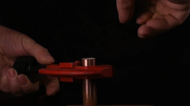 Handwerker schneidet Kupferrohr