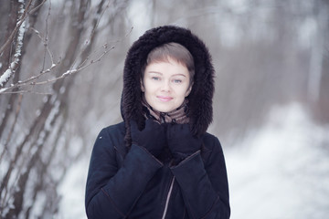 Winter woman in a fur coat on the snow outside