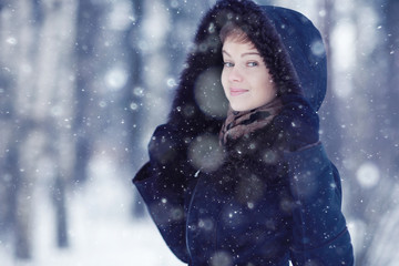 Winter woman in a fur coat on the snow outside