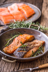 Salmon fillets. Grilled salmon, sesame seeds herb decorationon on vintage pan or black slate board. fish roasted on an old wooden table.Studio shot.