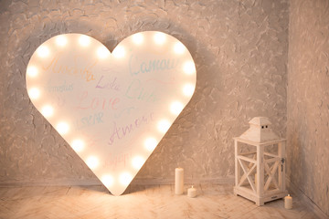 Large glowing heart in the room with candles