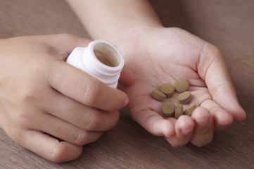 herb medicine in pill on hand holding with white bottle