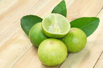Fresh lime fruit sour taste with a half on wood background.