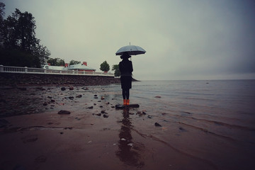 Fototapeta na wymiar woman with an umbrella by the sea wind rain
