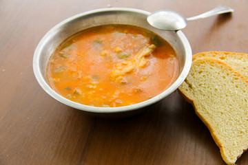 Traditional russian soup rassolnik with pickled cucumbers in metal bowl