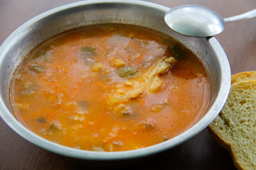 Traditional russian soup rassolnik with pickled cucumbers in metal bowl