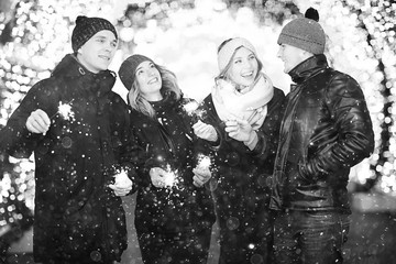 group of young people with sparklers Christmas party winter snow city