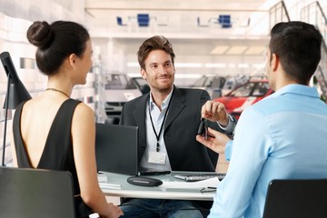 Businessman handing over car keys at dealership