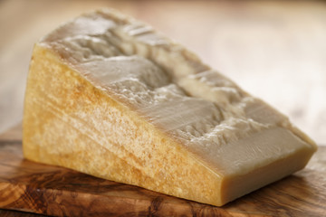 big chunk of italian parmesan cheese on wooden cutting board, simple rustic photo