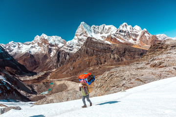 Nepalese Porter carrying Basket with luggage of mountain expedition