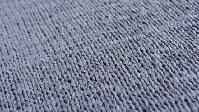 Slow tilt on gray female sweater knitwork close-up texture 4K 2160p 30fps UltraHD footage - Shallow DOF knitting details of women cloth 3840X2160 UHD tilting video 