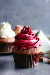 Tasty chocolate cupcake on grey textured surface
