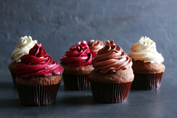 Tasty chocolate cupcakes on grey textured surface