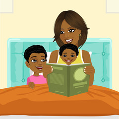 african american mother reading a book to son and daughter in bed before going to sleep