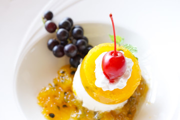 Panna cotta decorated with berries closeup, passion fruit panna cotta, or mango panna cotta
