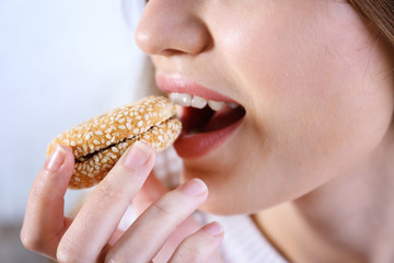 Young woman eating cookie, closeup