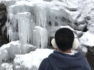 muchacha contemplando los carambanos formados en las rocas por el frio extremo