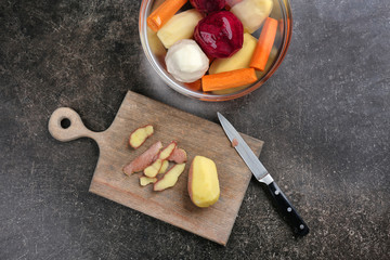 Bowl with  vegetables and cutting board on grey background
