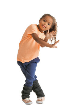 Cute African American girl dancing on white background
