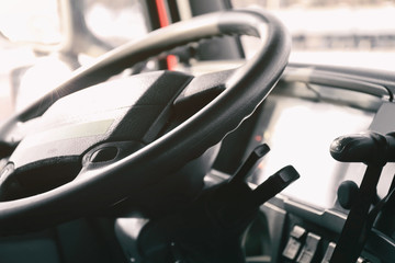 Steering wheel in cabin of big truck, closeup
