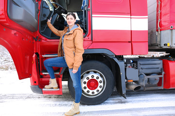 Female driver near big modern truck outdoors