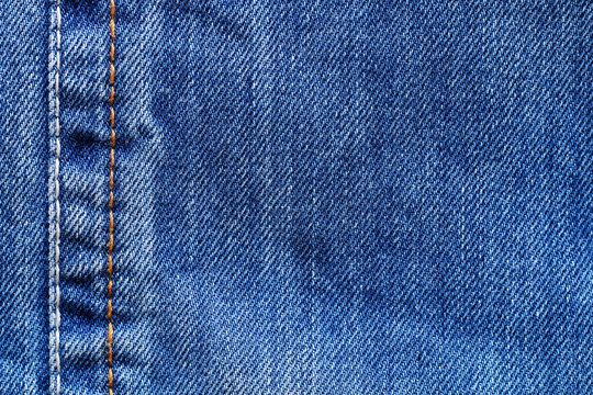Texture of blue denim with seam.