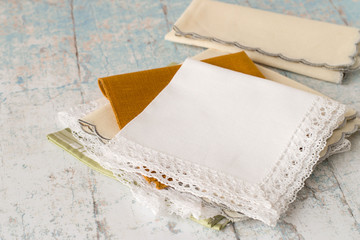 
 Handkerchiefs.   Net neatly folded handkerchiefs on the old wooden table. - obrazy, fototapety, plakaty
