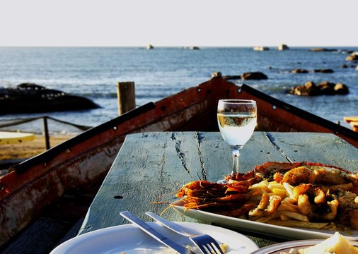 glass of white wine and plate seafood, selective focus