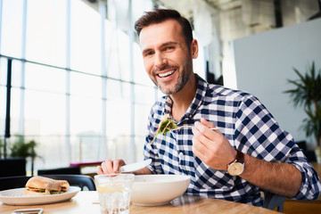 Smiling man eating in cafe
