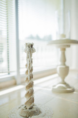 Beige wooden candlestick covered with white wax