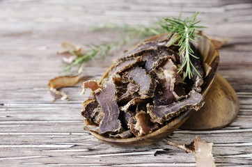 jerked meat, cow, deer, wild beast or biltong in wooden bowls on a rustic table