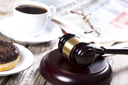 Family law concept. Gavel, newspaper and coffee on wooden table 