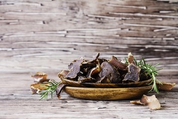 jerked meat, cow, deer, wild beast or biltong in wooden bowls on a rustic table
