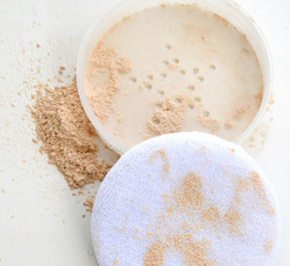 crushed crumbled natural powder make up with pack on white background