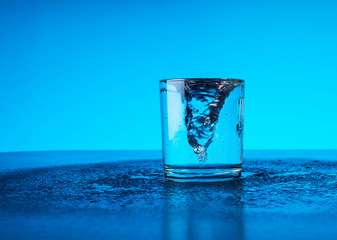 fresh clear blue water splash in glass