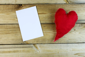 Fluffy elongated red heart, handmade with photo paper on an old wooden table