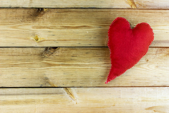 Fluffy elongated red heart, hand made on the old wooden table