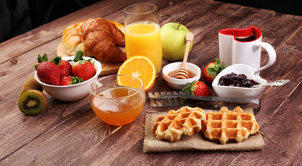 breakfast in bed with fruits and pastries on a tray -waffles, croissant