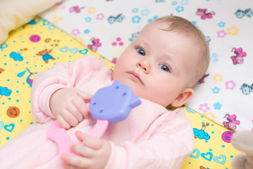 Cute baby lying on his stomach in his bed.
