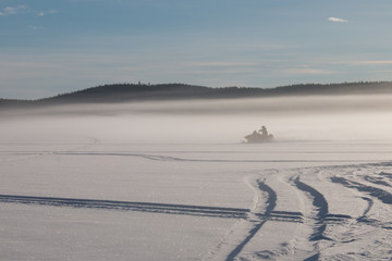 One person riding a snowmobile on a frozen lake in Sweden 